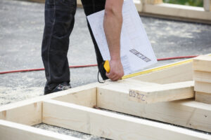 construction worker measuring modular building