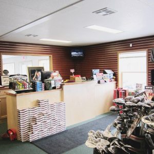 cash register counter with golf clubs and stacked golf balls